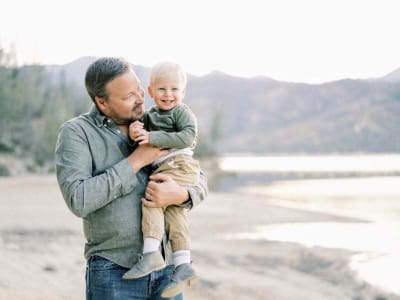 Dr. Burlingame holding his son at the lake
