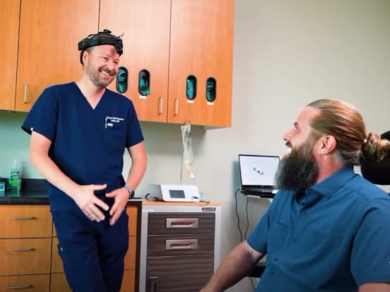 Dr. Shaun Burlingame sharing a laugh with a patient in a Riverside Oral Surgery treatment room