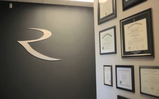 The lobby wall with the Riverside R brand mark and the doctors’ credentials