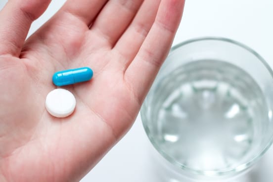 Prescribed oral sedation medication beside a glass of water