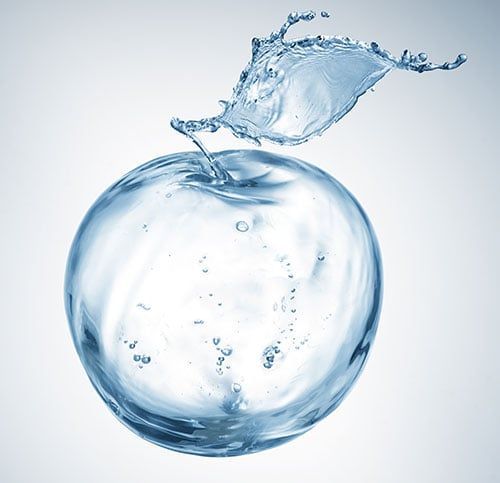 Glass of water and an apple, reminders of the pre-sedation fasting rules